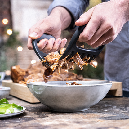 BBQ meat claws held in hands, dark charcoal grips with pointed tines