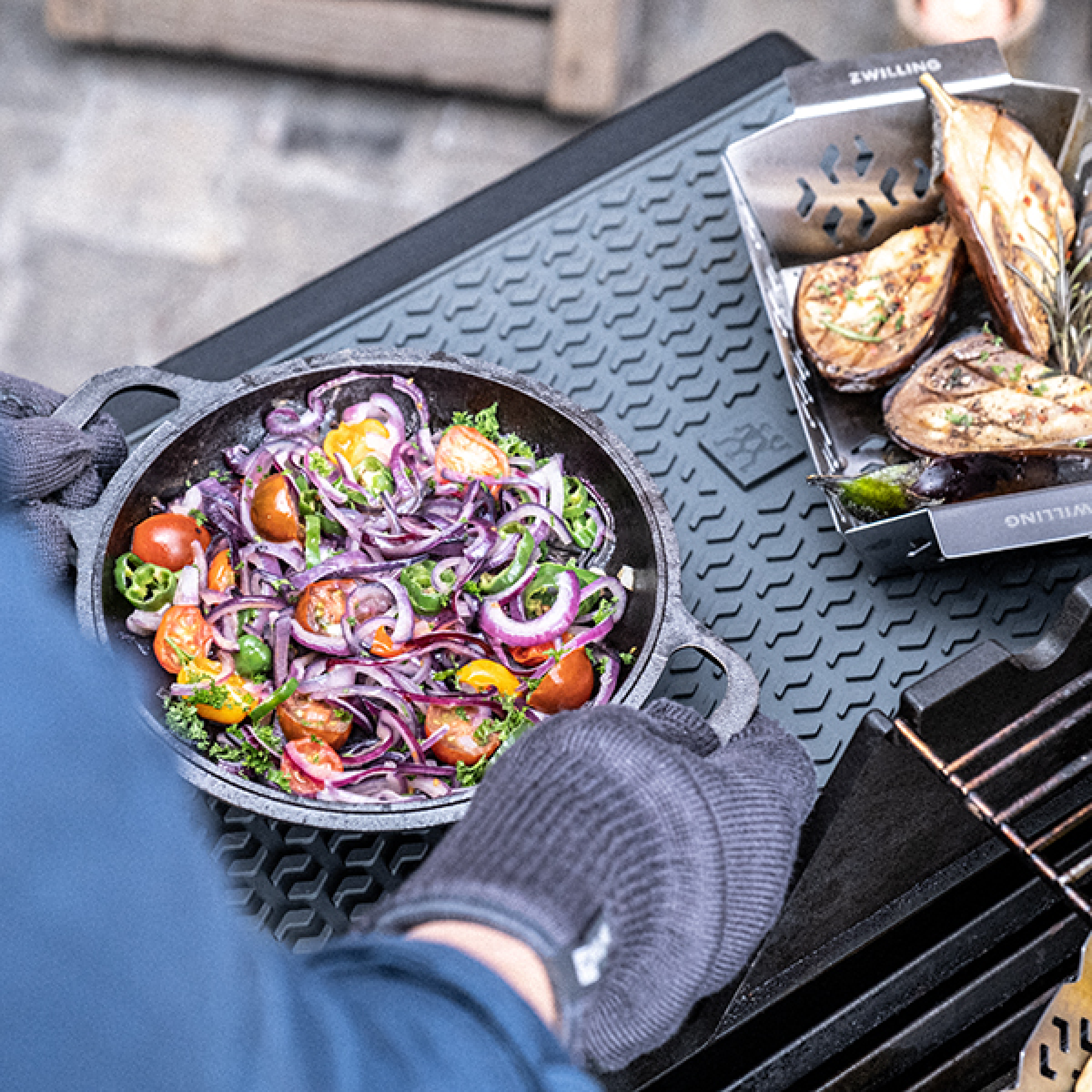 Silicone protection mat on BBQ grill with pan of vegetables and onions