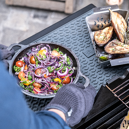 Silicone protection mat on BBQ grill with pan of vegetables and onions
