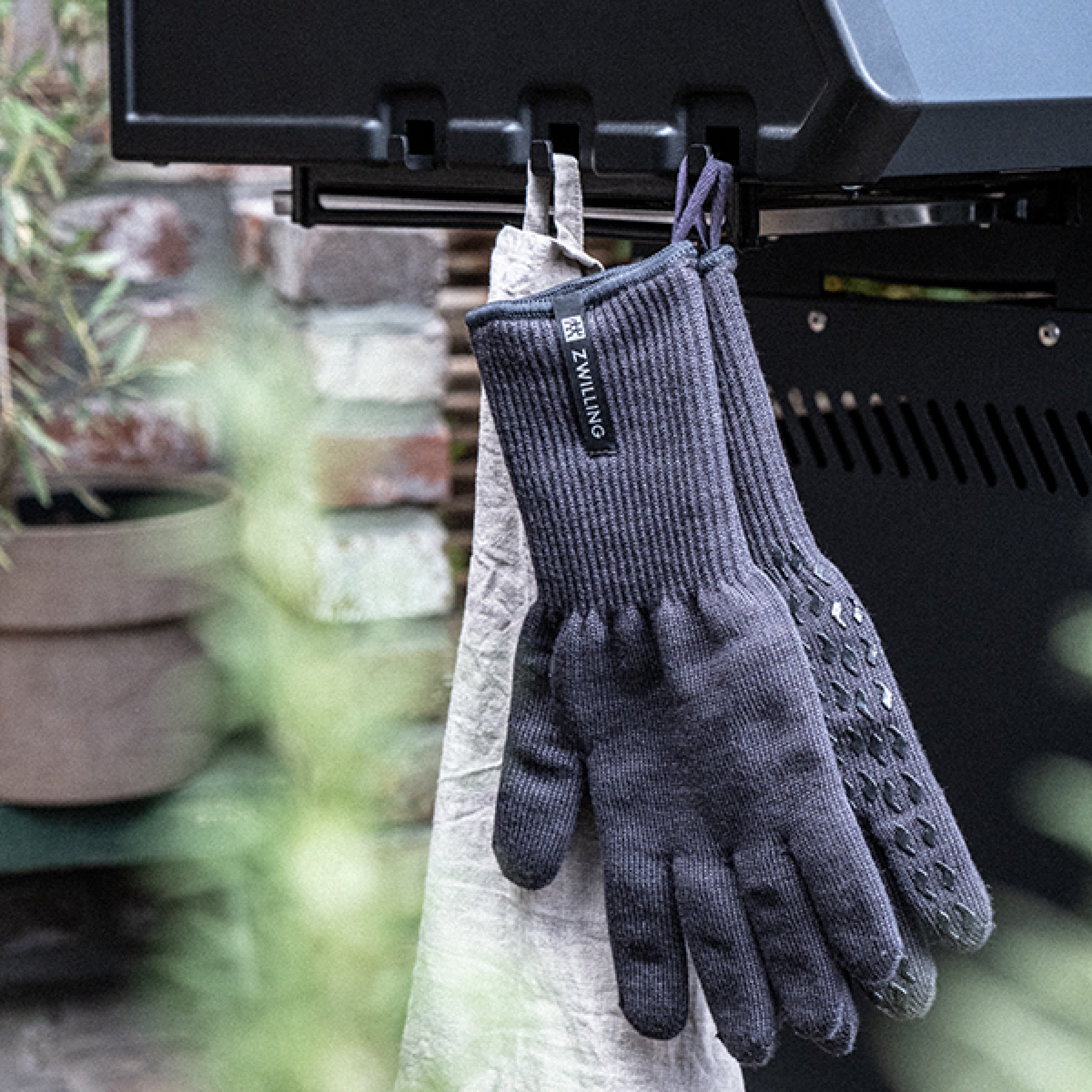 ZWILLING BBQ protection gloves pair hanging, dark gray knit with textured palm grip