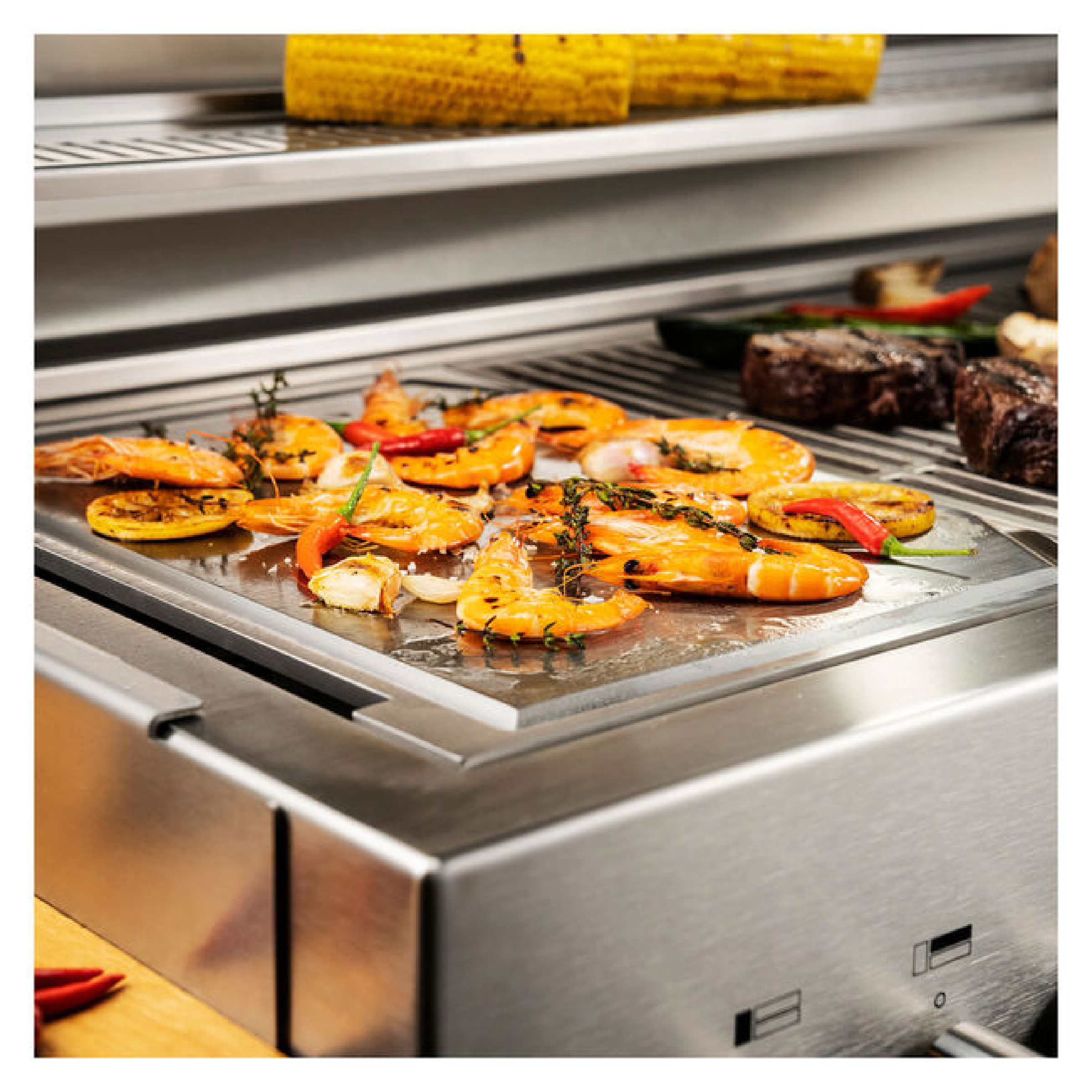 Teppanyaki griddle cooking surface with sizzling seafood and vegetables