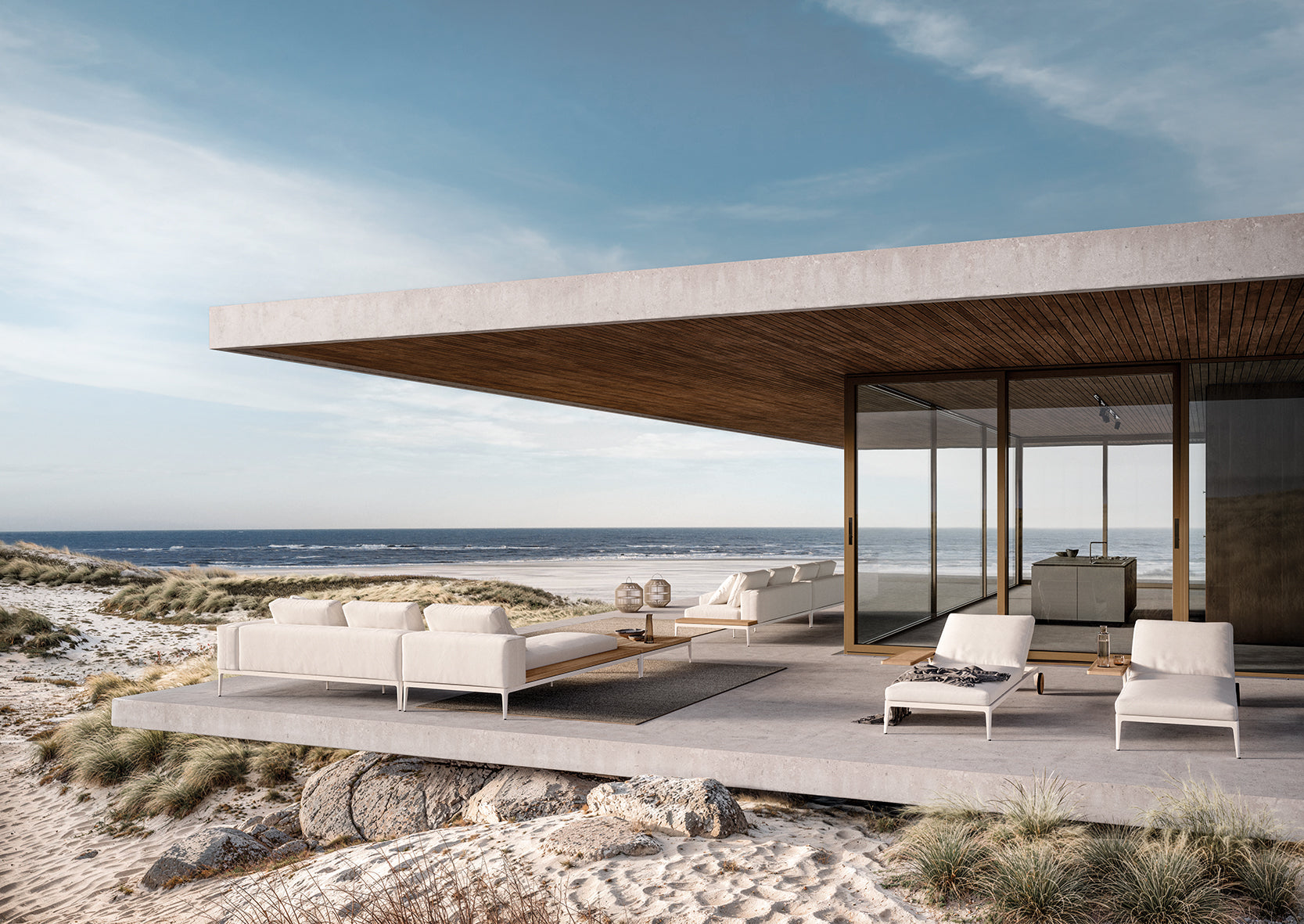 Gloster Grid sectional sofa and lounge chairs on a beachfront terrace