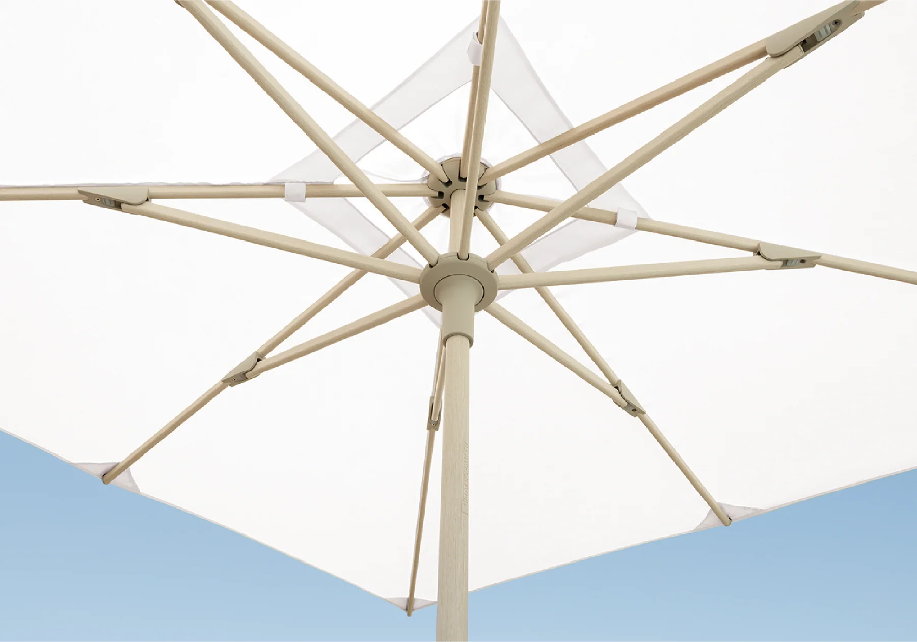 Detail shot of a white umbrella with blue sky in background
